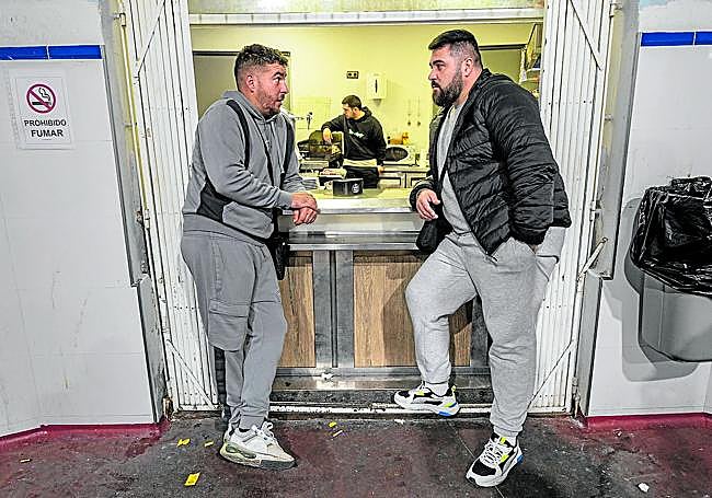 Felipe Ruiz y su primo José Domingo Cabrera comparten charla en la ventana de la cantina de la lonja.
