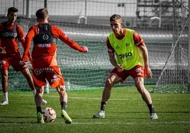 Alberto González, con peto amarillo, defiende ante Loren Burón, de espaldas, en una acción durante un entrenamiento del Real Murcia.