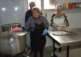 Unos voluntarios preparan la comida en la cocina del comedor social en Cieza.