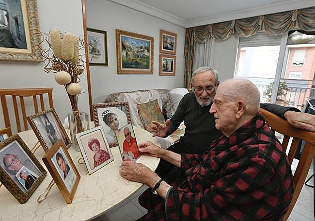 El voluntario de FADE Manuel Pérez revisa fotos con Pepe Salinas, un hombre de 83 años al que visita en su casa desde mayo.