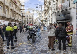 Policías locales y bomberos, este domingo, en la puerta del establecimiento incendiado.
