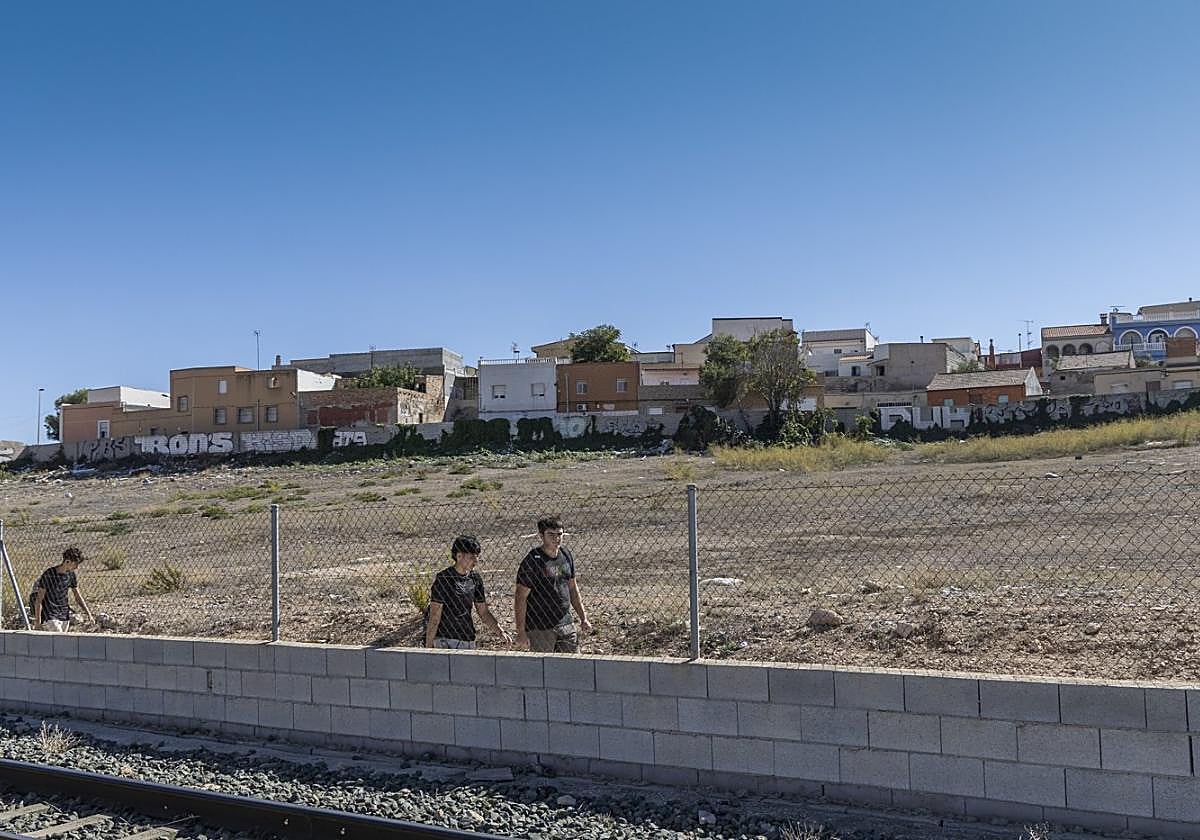 Varios adolescentes pasan junto a los terrenos de Los Mateos donde el Ayuntamiento prevé construir viviendas asequibles para jóvenes, en una imagen de archivo.