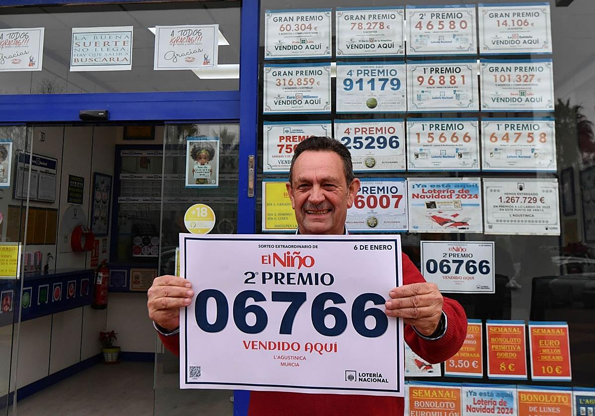 El lotero de la administración del Paseo de Florencia de Murcia celebra haber repartido el segundo premio de la Lotería del Niño.