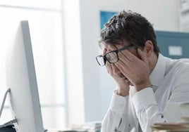 Un trabajador cansado delante de su ordenador.