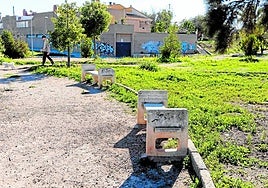 Un chico pasea a su mascota este viernes por el parque de Escipión, en Los Barreros, donde se observa la descuidada vegetación y el estado de las instalaciones.
