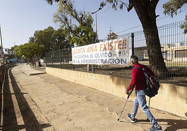 Un vecino de Santa Ana pasa frente a una pancarta de «¡Santa Ana existe!», que denuncia la situación de abandono del pueblo