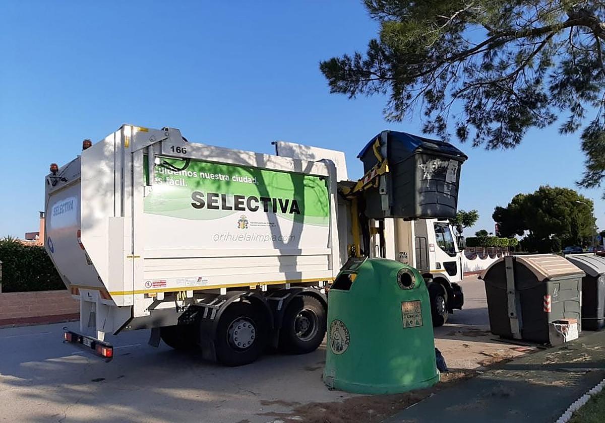 Un camión de selectiva del servicio de basuras de Orihuela vacía un contenedor.