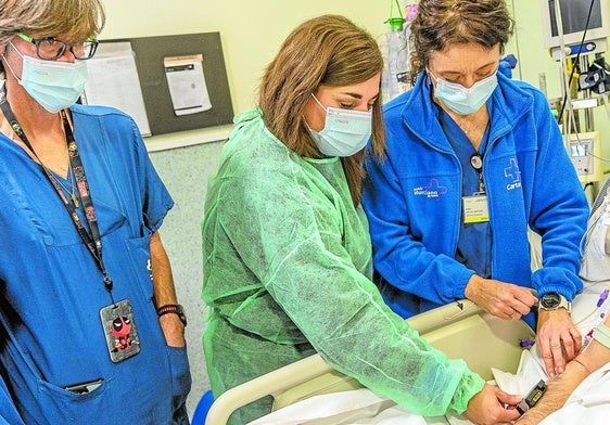 Médicos del Hospital Santa Lucía y participantes en el proyecto de la UCAM colocan un sensor a un paciente en la UCI.