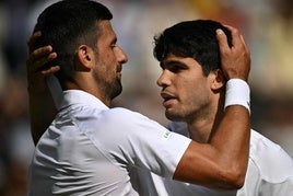 Novak Djokovic y Carlos Alcaraz se saludan tras la última final de Wimbledon, donde ganó el tenista murciano.