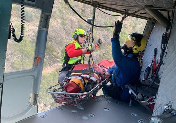 Efectivos rescatan al senderista y lo trasladan a bordo de un helicóptero.