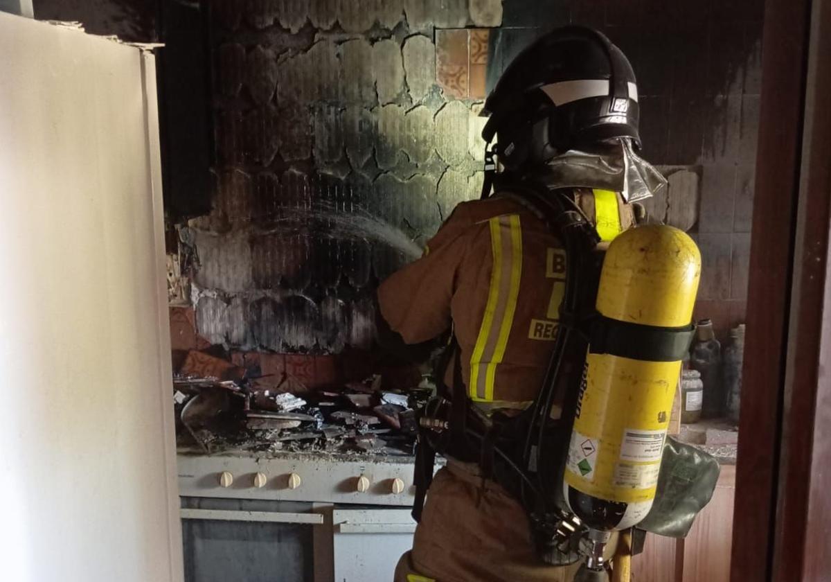 Un bombero apaga el incendio de la vivienda de Lorca, este viernes.