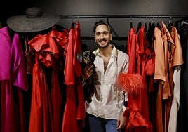 El diseñador Manuel de la Vega posa junto a su perro, 'Liillo', y rodeado de sus vestidos.