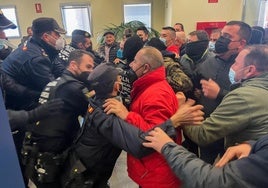 Momento en el que los policías intentan frenar a los ganaderos, ya en el interior del edificio.