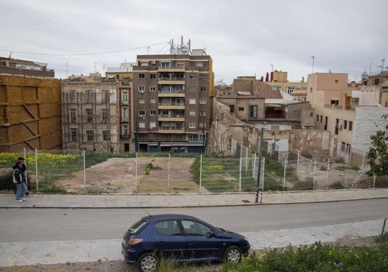 Dos personas pasan frente a uno de los solares abandonados que da a las calles Cuatro Santos y Concepción.