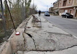 Un vecino camina por la acera de la calle Mayor de El Esparragal, en la que el firme está levantado y cuya situación ha derivado en una reclamación contra el Ayuntamiento.