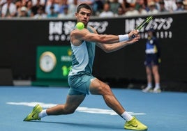 Carlos Alcaraz responde de revés durante un partido en el Abierto de Australia.