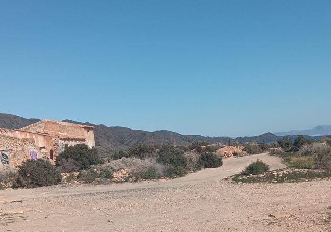 Explanada de la lorquina playa de Cala Blanca, con el edificio del cuartel abandonado al fondo, sin ninguna autocaravana aparcada