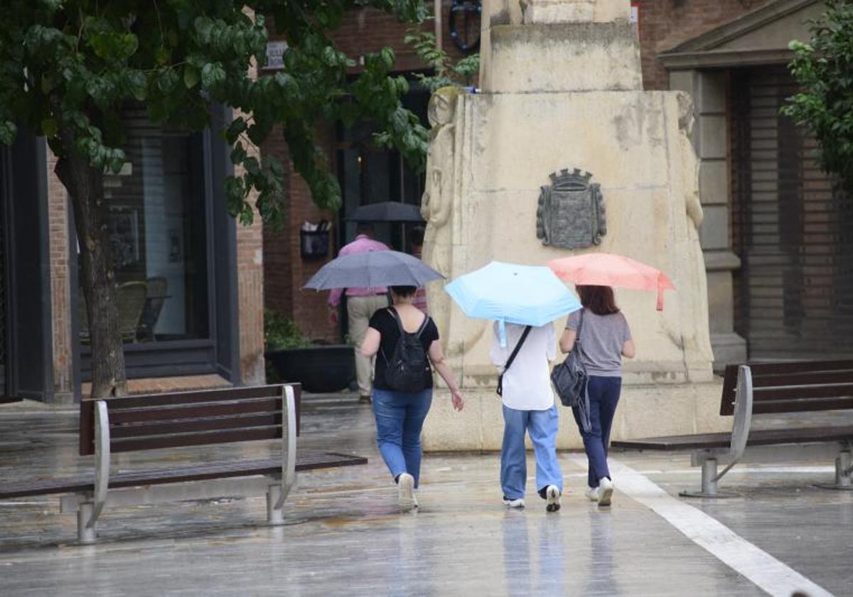 Un grupo de mujeres pasean por el centro de Murcia en un día de lluvia.