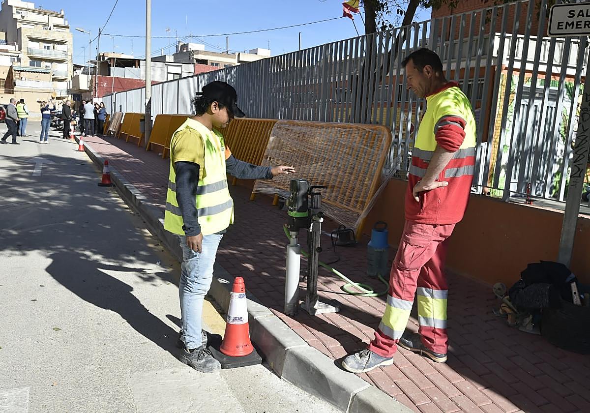 Dos operarios trabajan en el colegio de Puente Tocinos.