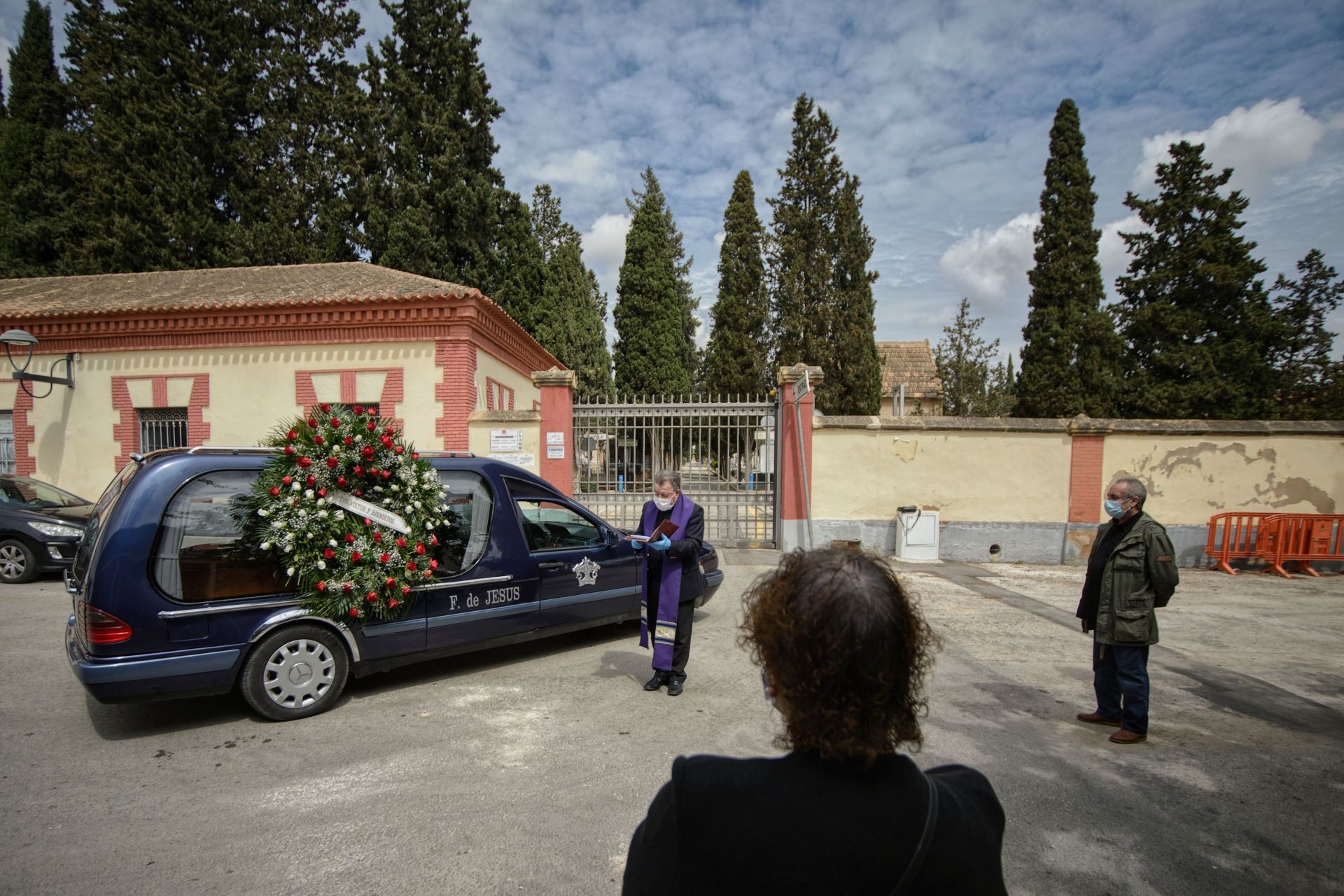 Un cura realizando un sepelio en la puerta del cementerio de Murcia. Nacho García