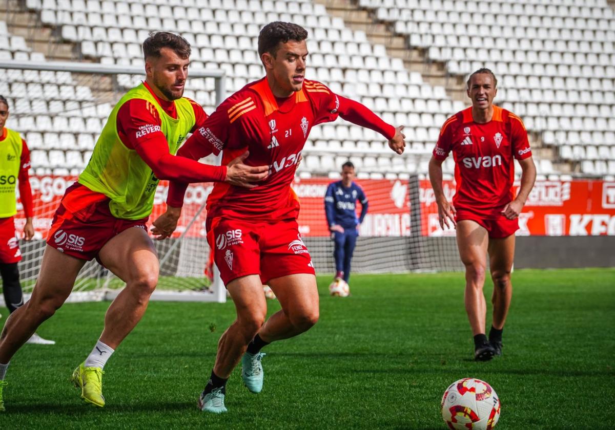 Raúl Alcaina persigue a Kike Cadete ante la mirada de Pedro Benito durante un entrenamiento del Real Mucia en el estadio Enrique Roca.