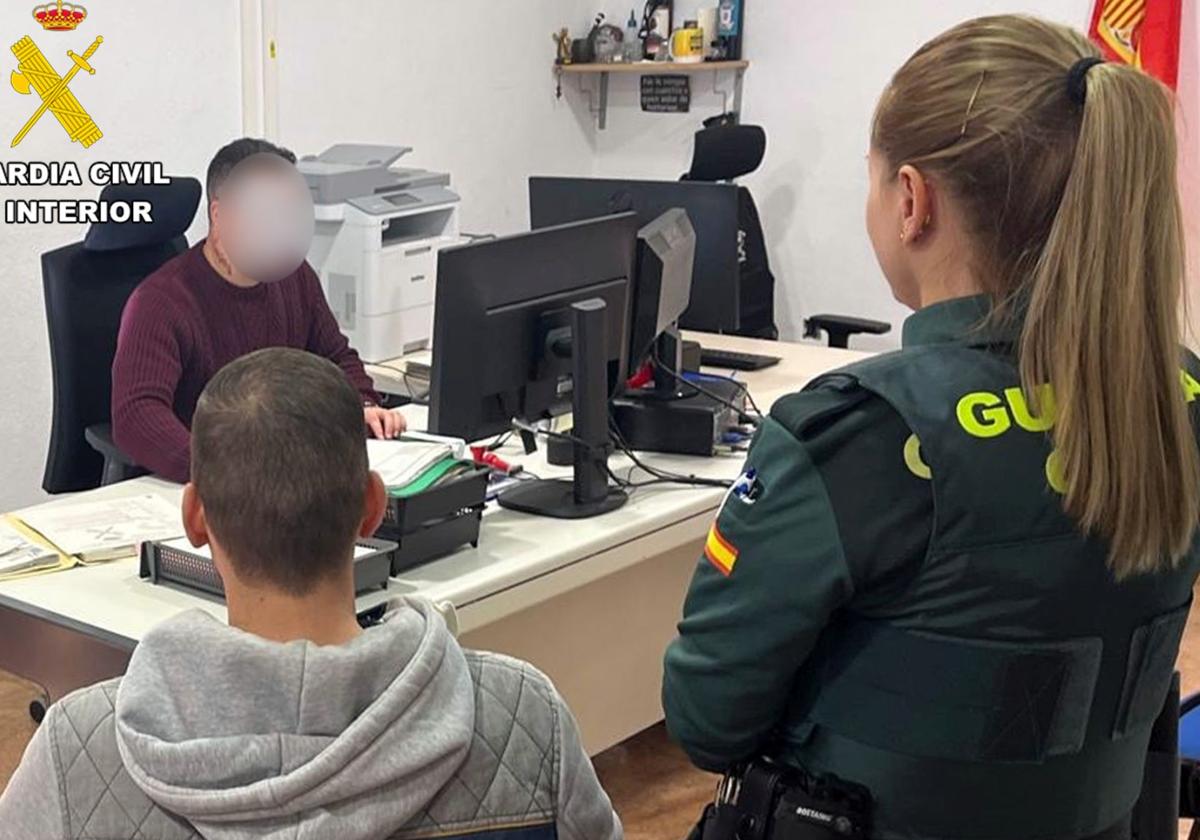 Una agente de la Guardia Civil junto a uno de los detenidos.