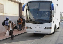 Varios jornaleros se bajan del autobús que les lleva a su zona de trabajo, en una imagen de archivo.