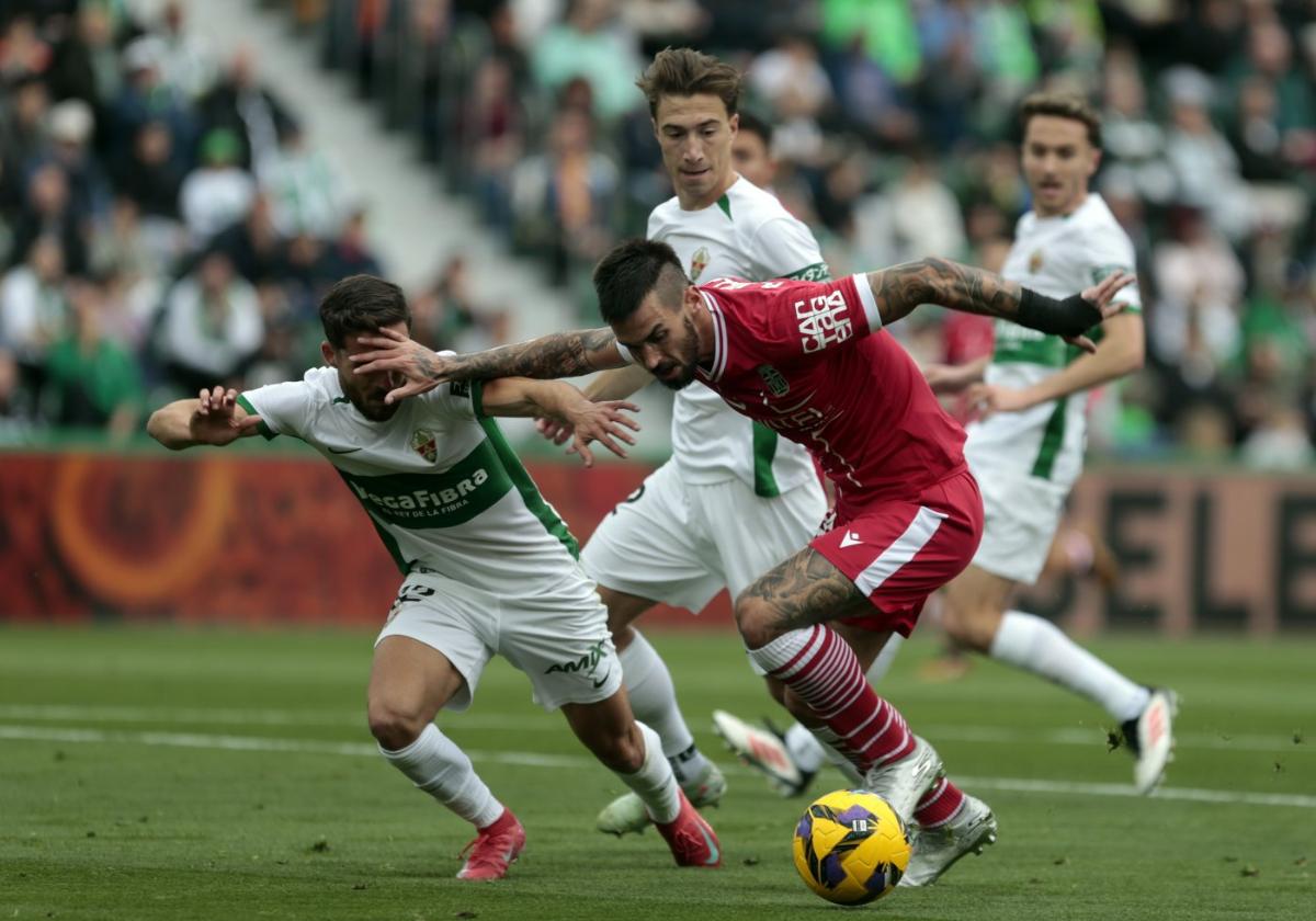 Álex Millán intenta zafarse de los defensas del Elche, ayer, en la derrota del Efesé en el Martínez Valero.