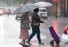 Dos mujeres paseando por Murcia durante una tormenta, en una imagen de archivo.