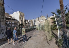 Tres hombres transitan por la calle Morería Baja, donde hay restos arqueológicos.