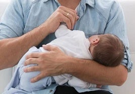Un bebé en brazos de su padre.