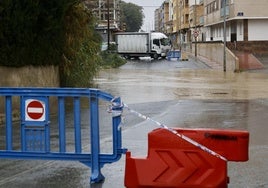 Una calle cortada en Beniaján por el paso de la rambla del Garruchal llena de agua.