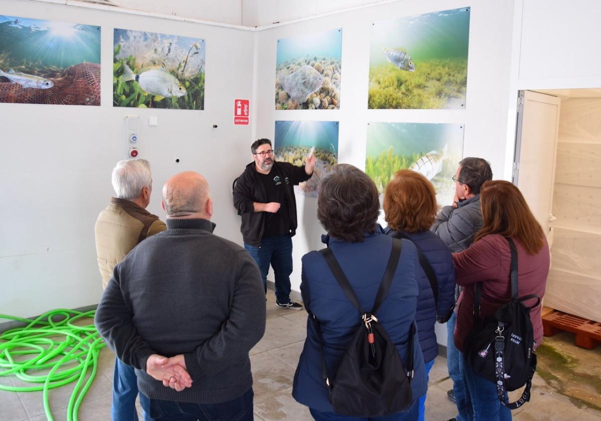 El secretario de la Cofradía de Pescadores , Carlos Sala, explica a los visitantes el funcionamiento de la subasta y las especies del Mar Menor.