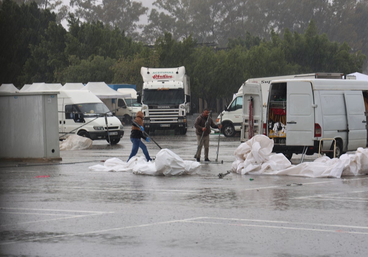 Vendedores se apresuran a desmontar sus puestos por la lluvia en el mercado semanal.