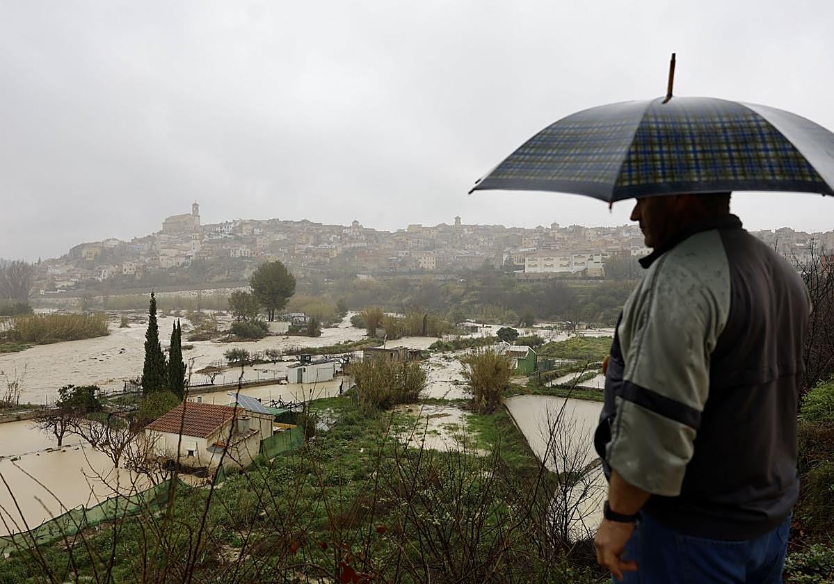 Un hombre en el caudal del río Argos, este jueves, con la localidad de Cehegín al fondo.