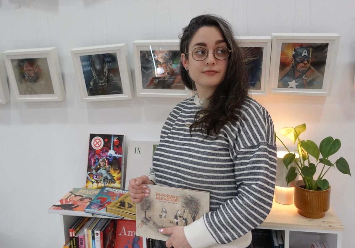 Fátima González, encargada de 7 Héroes, posa con la selección de cómics escogida por la librería.