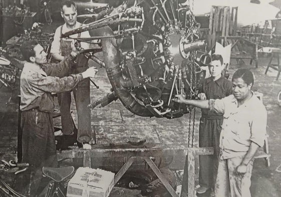 José Frimán y otros empleados manejando un motor de avión, en los talleres de San Javier (década 1950).