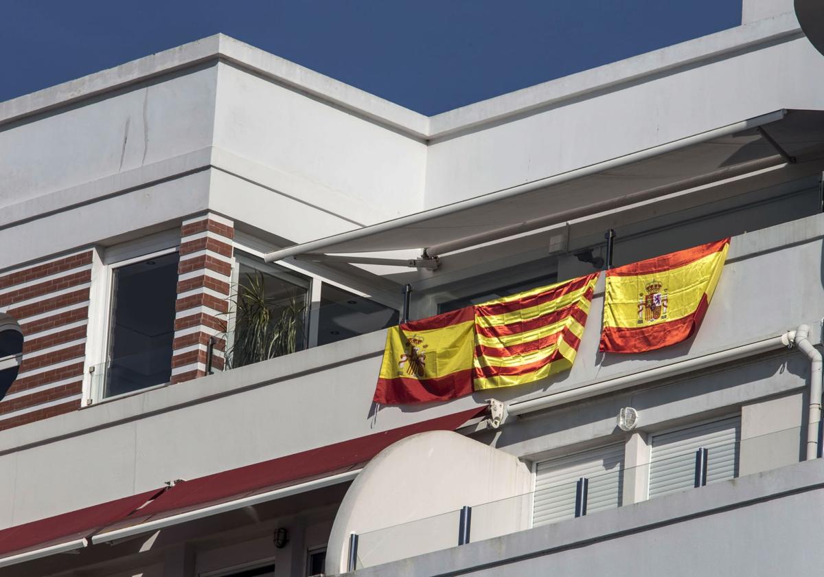 Dos banderas españolas y una senyera catalana comparten balcón en la calle Castelar.