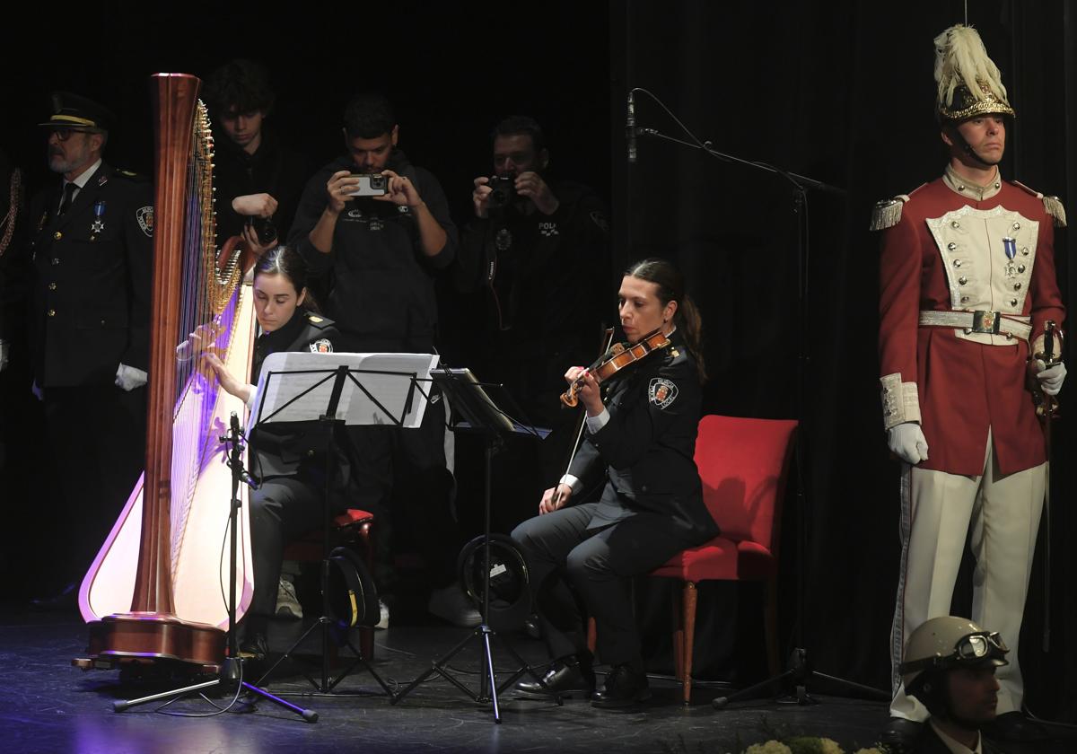 Dos agentes interpretan música durante el acto con motivo del patrón de los policías.