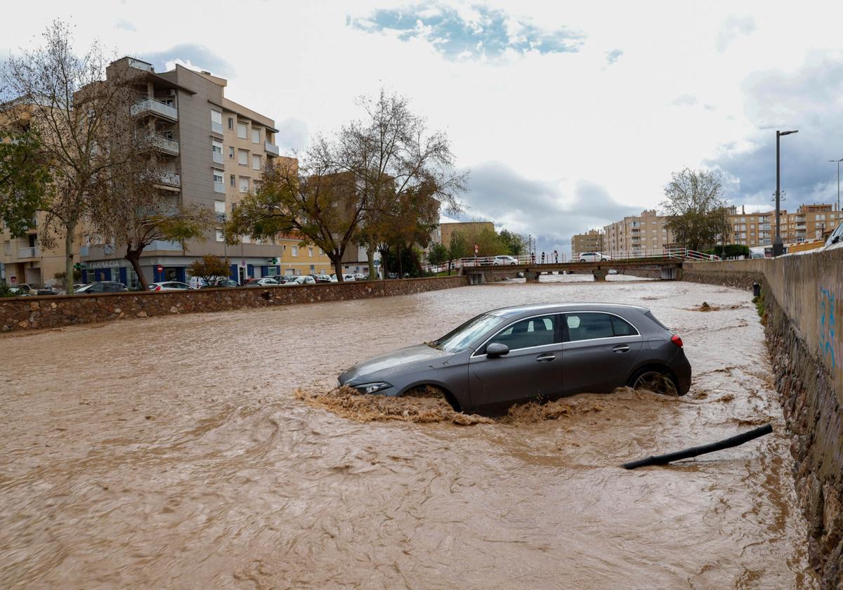 Un coche arrastrado por el agua en una rambla de Águilas, este martes.