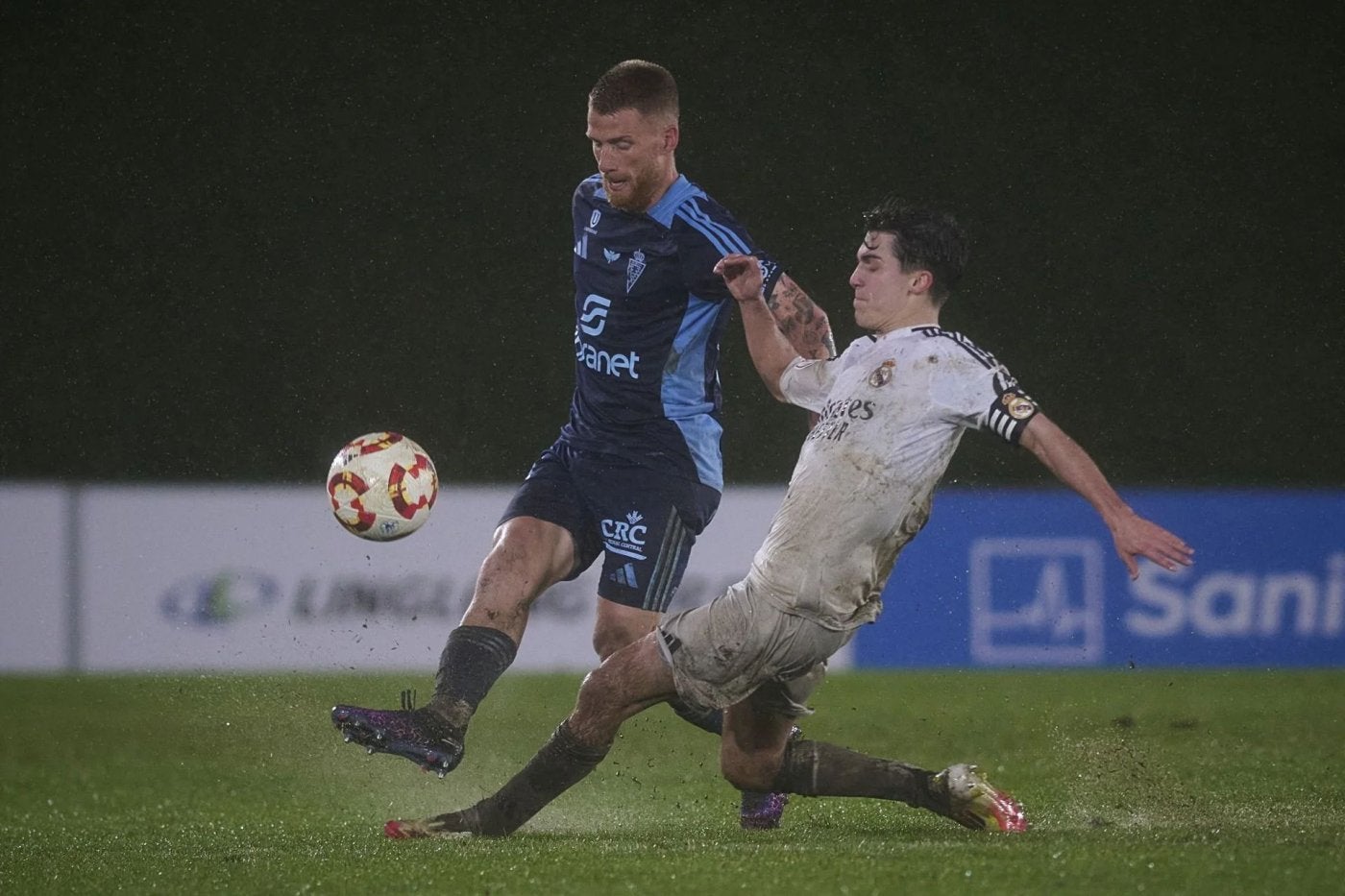 David Vicente despeja un balón ante la presión de Manuel Ángel, centrocampista del Real Madrid Castilla.