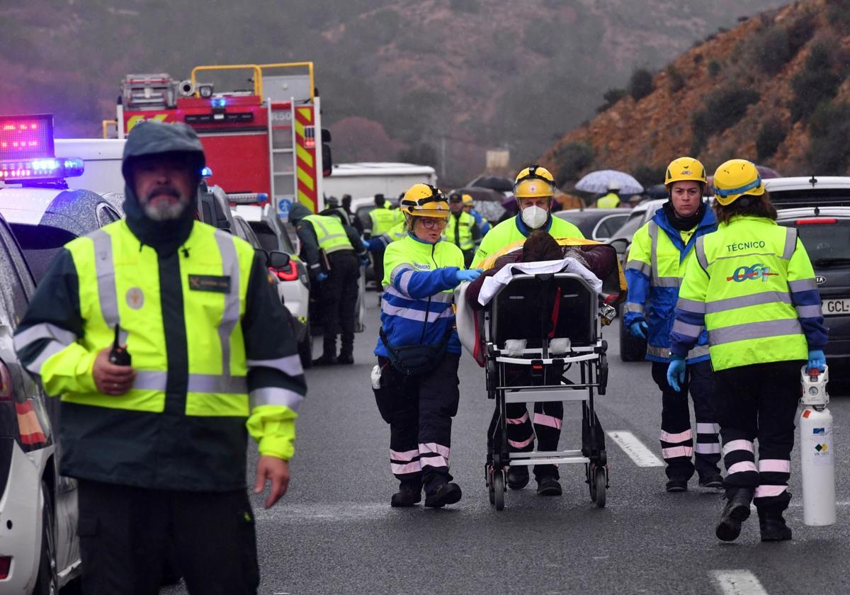 Sanitarios trasladan a uno de los heridos, tras el vuelco del autobús, el pasado martes.