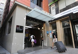 Turistas entrando en un hotel del centro de Murcia.