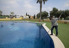 Rubén Gallego limpia la piscina del alojamiento rural que regenta en Perín, junto a las sierras de La Muela y el monte Roldán.
