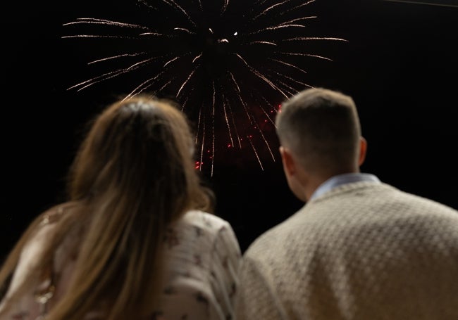 Una pareja contempla el espectáculo de fuegos artificiales en el cielo de Molina de Segura.