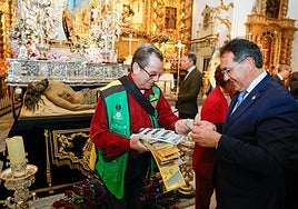 El concejal de Turismo compra el cupón conmemorativo ante el Cristo Yacente, en la iglesia de San Francisco.