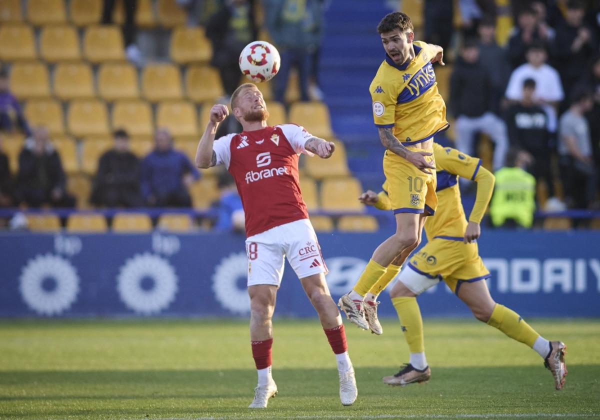David Vicente, jugador del Real Murcia, disputa un balón aéreo con Rayco, del Alcorcón.
