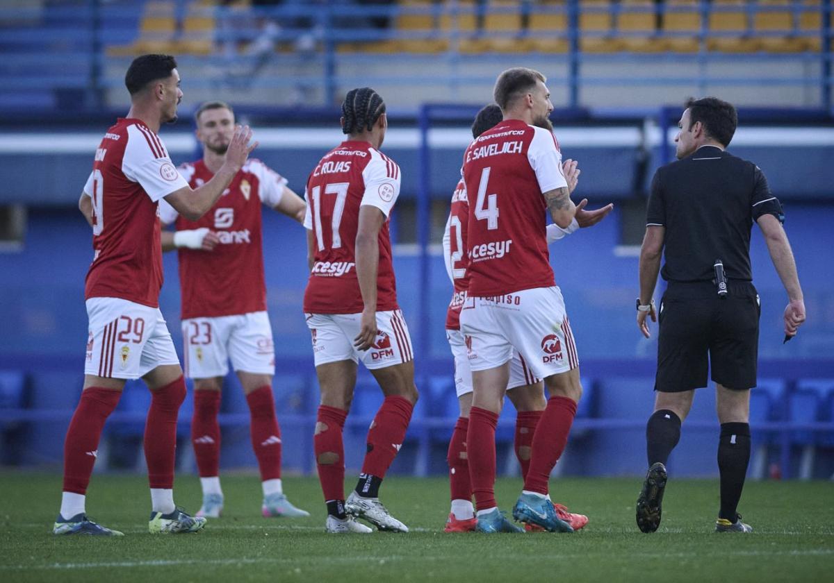 Varios jugadores del Real Murcia como Cadorini, Rojas y Saveljich protestan a Román Román, árbitro del partido ante el Alcorcón.