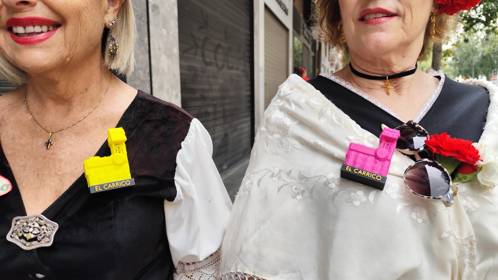 Otra costumbre popular del Bando de la Huerta es llevar pines de las peñas huertanas a las que pertenecen los asistentes. Mari Carmen y María José, enseñan con orgullo sus pines de la Peña El Carrico, que definen como «una agrupación familiar y de amigos».