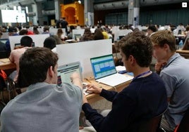 Jóvenes asistentes a un programa de educación financiera manejando recursos informáticos.
